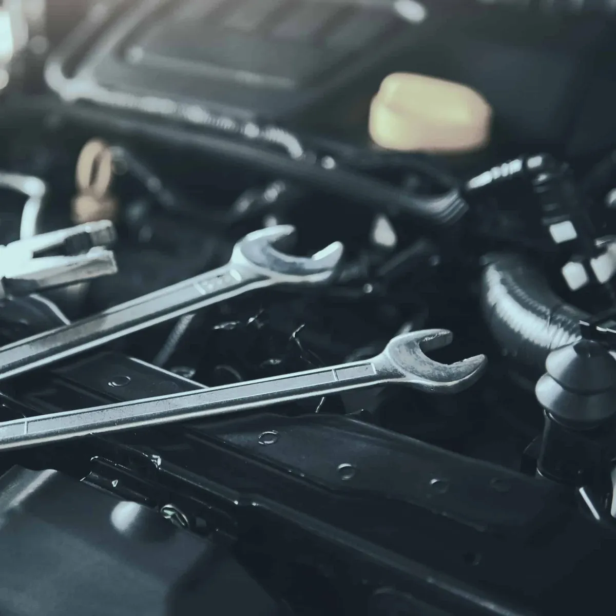 Mechanic's hands checking and repairing broken car in service garage